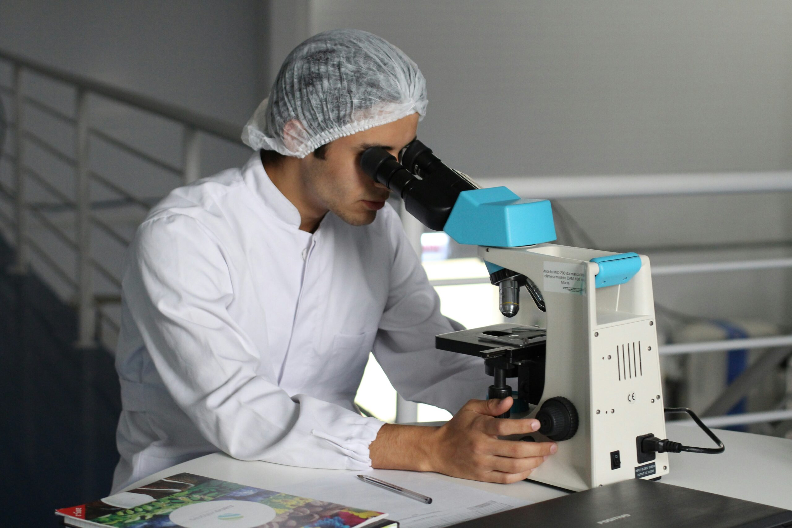 "Medical robotics" man sight on white microscope